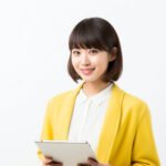 大型のタブレットを持ちながらカメラ目線をする女性