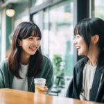 喫茶店の店内でとても嬉しそうに話すロングヘアーの女性