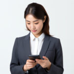 スマホで友達とメッセージをやりとりする女性社員