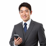 スマホを手に最新のニュースを読む男性社員