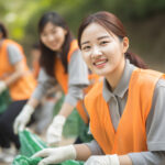 協力して公園でゴミ拾いをする女性