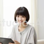 ニヤッとしながらタブレット型端末を持つ女性