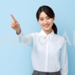 横を指で差す会社員女性