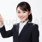 人差し指を真上に挙げて合図する会社員女性