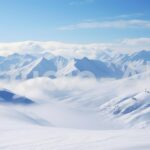 青空に映える雪山の頂上からは無限の広がりを感じる絶景が見える