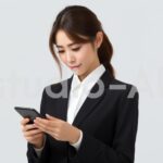 こちらを見つめてスマホを持つ会社員女性