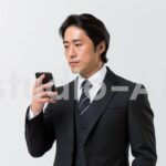 スマホを持ちながら遠くを見つめる男性社員