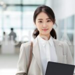 立ち姿の女性会社員がタブレットを持つ姿