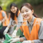 協力して公園でゴミ拾いをする女性